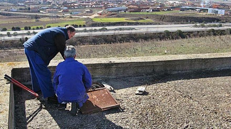 Operarios municipales realizan, hace diez años, limpieza del depósito de agua en el cerro &quot;La Corona&quot;.