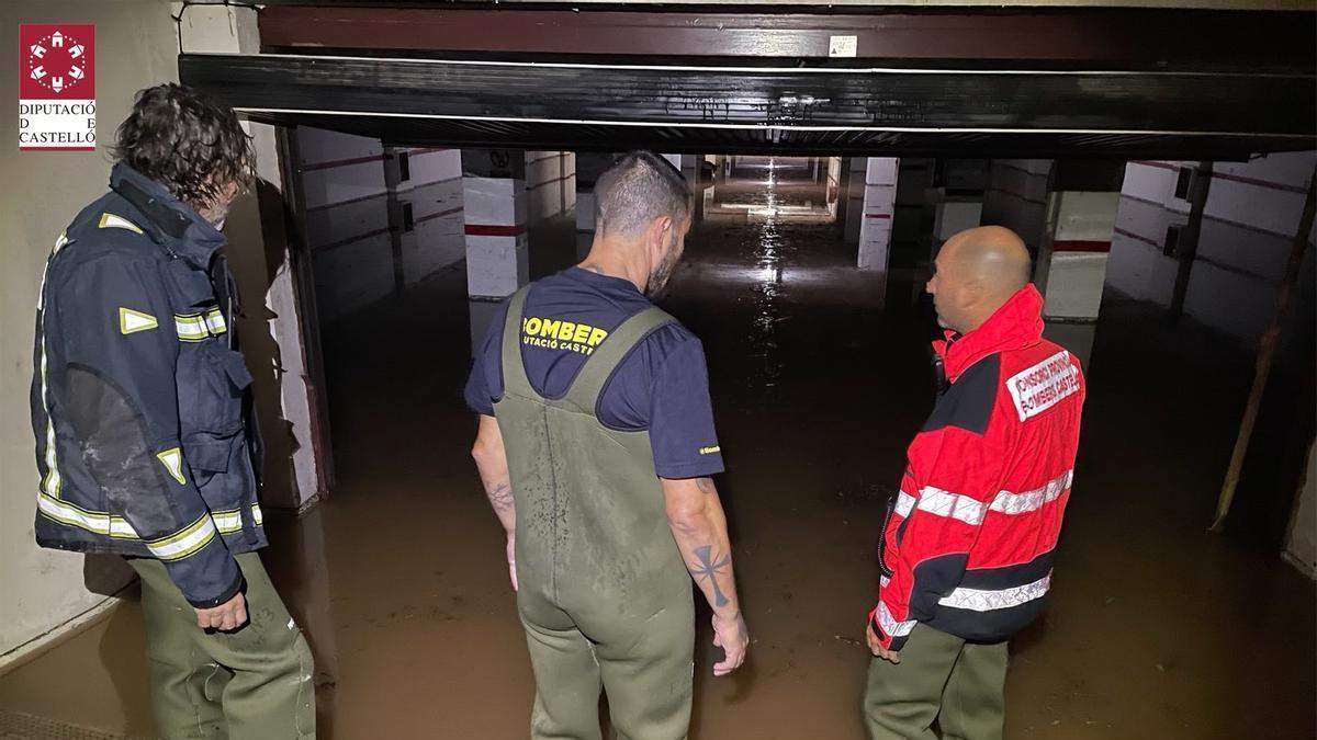 Imagen de los bomberos en un párking inundado.