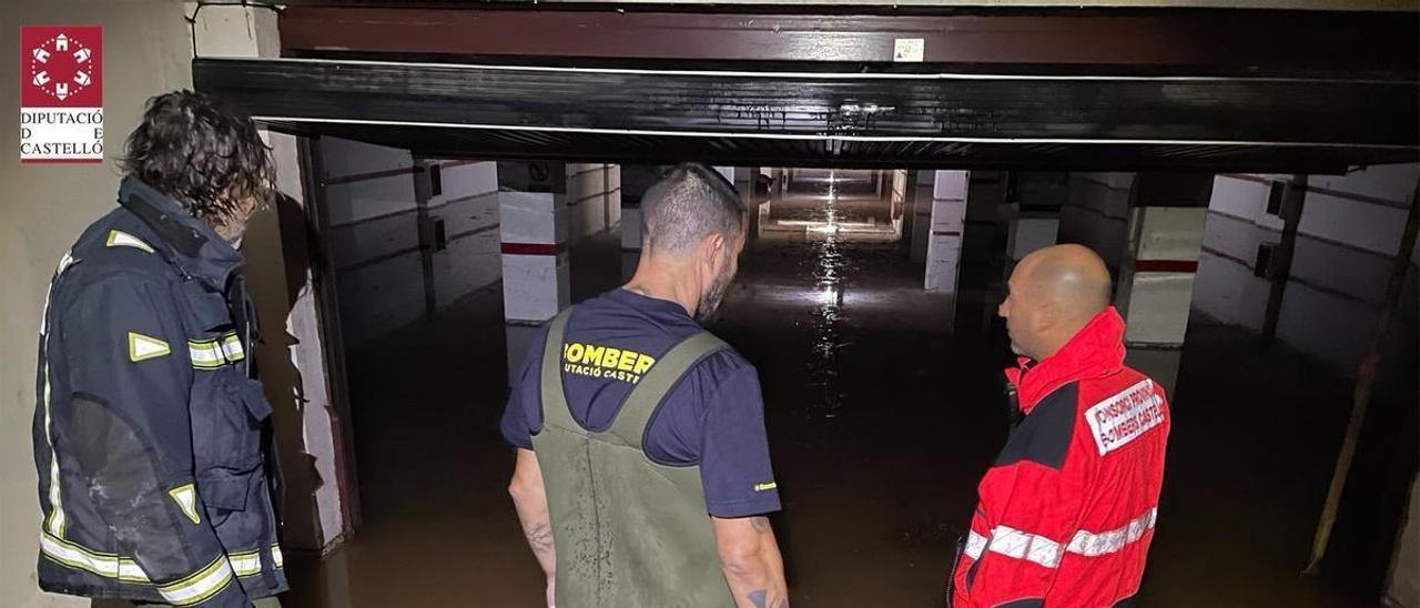 Imagen de los bomberos en un párking inundado.