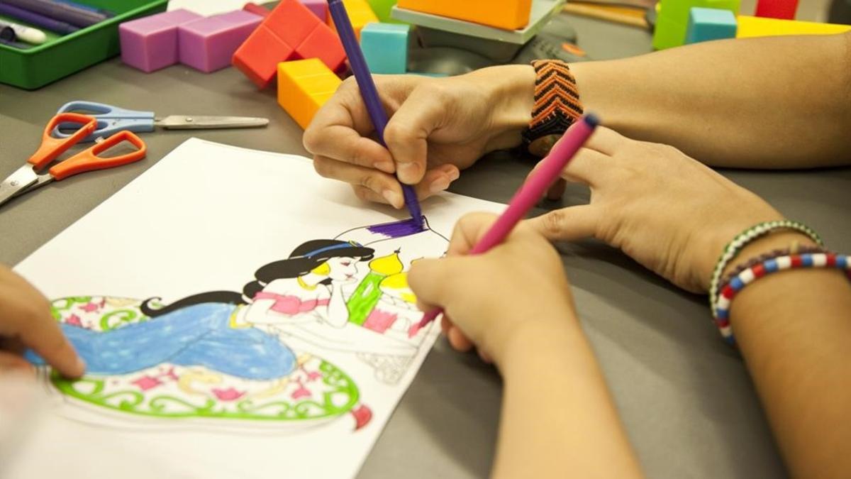 Unos niños coloreando un dibujo de Disney en una imagen de archivo.