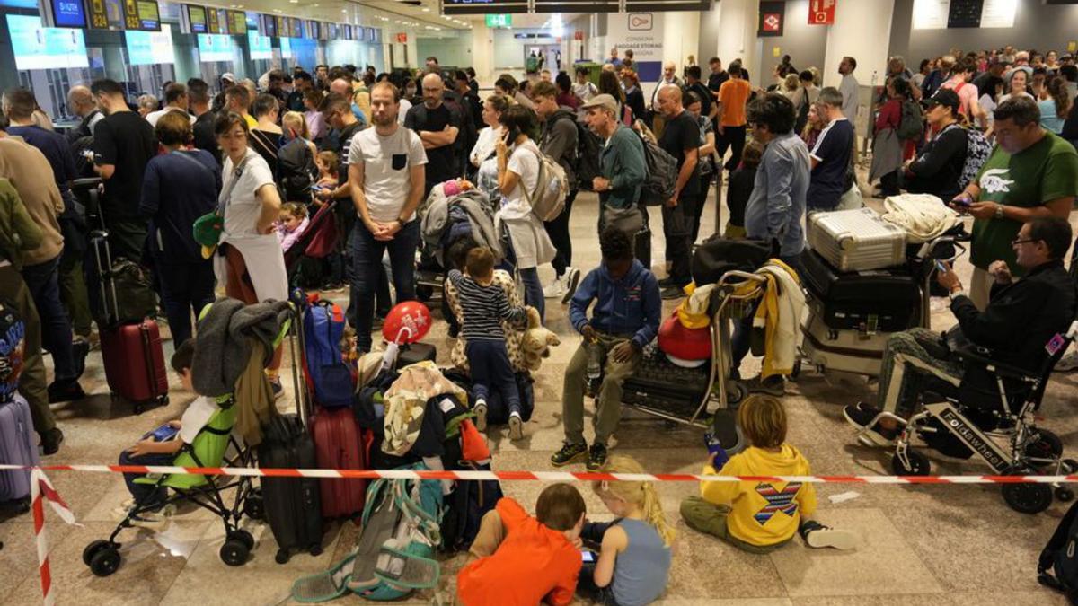 Viajeros esperando para poder volar en el aeropuerto de El Prat, este lunes