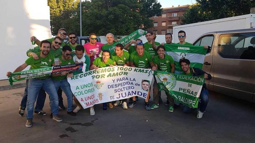 Aficionados del Betis, en una parada realizada ayer durante el viaje a Asturias, con la pancarta que hace ilusión al hermanamiento con el Sporting y a la despedida de soltero que celebrarán en Gijón.