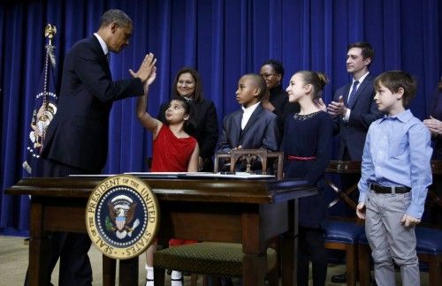 U.S. President Obama high-fives child after announcing proposals to counter gun violence during event at the White House in Washington