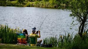 Una pareja pesca en un río en una zona permitida