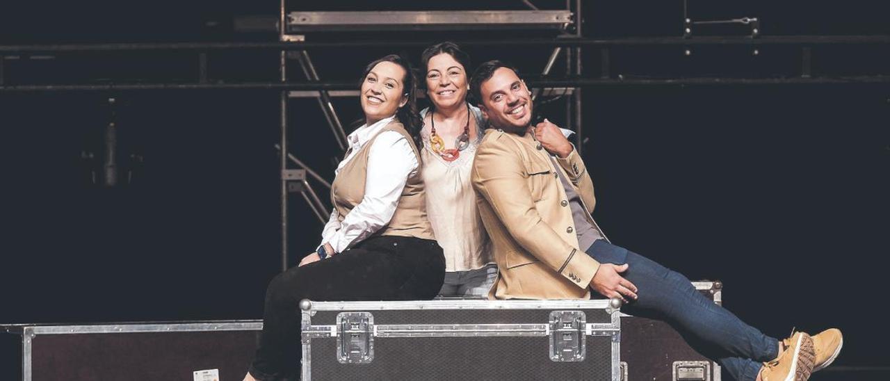 La productora Nati Santana —centro— fotografiada en el escenario del Auditorio de Agüimes junto a sus hijos Circe y Aarón Santana, presente y futuro de Camino Viejo.
