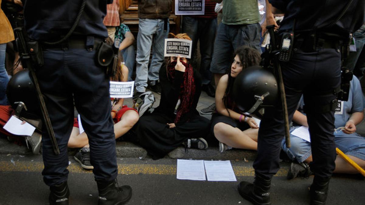 Los indignados del 15-M y la Asociación de afectados por la Hipoteca protestante ante una entidad de Bankia el pasado mes de mayo