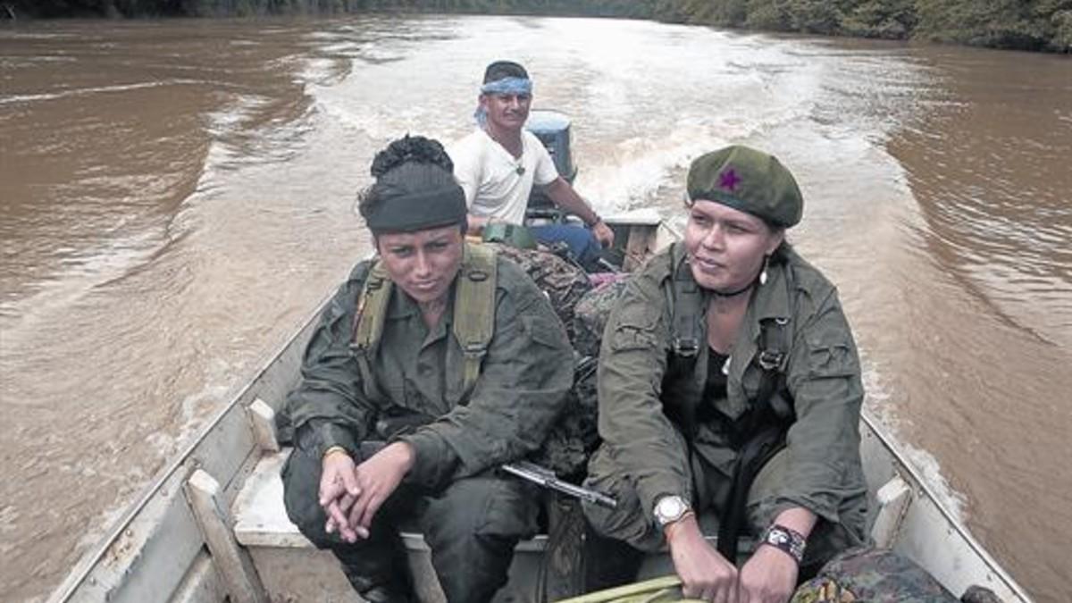 Dos guerrilleras, deplazándose en lancha por uno de los ríos de la región de Caquetá.