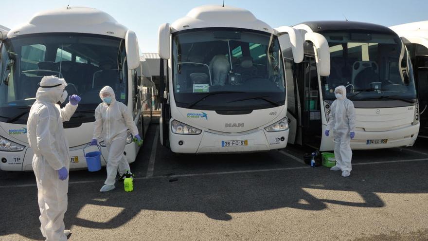 Operarios de limpieza se disponen a desinfectar una flota de autobuses en Caldas da Rainha (Portugal).