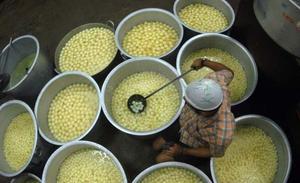 Un treballador prepara dolços en una fàbrica de Madràs, al sud de l’Índia.