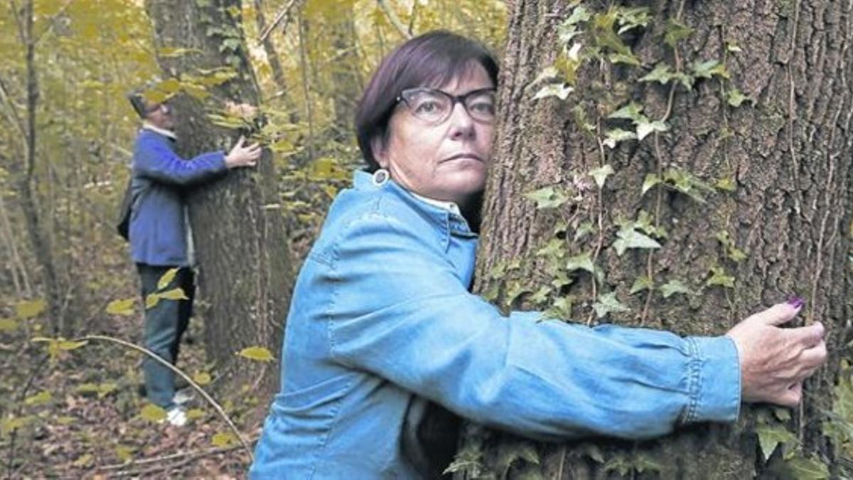 Participantes en el ensayo clínico pasean por el bosque y se abrazan a los árboles.