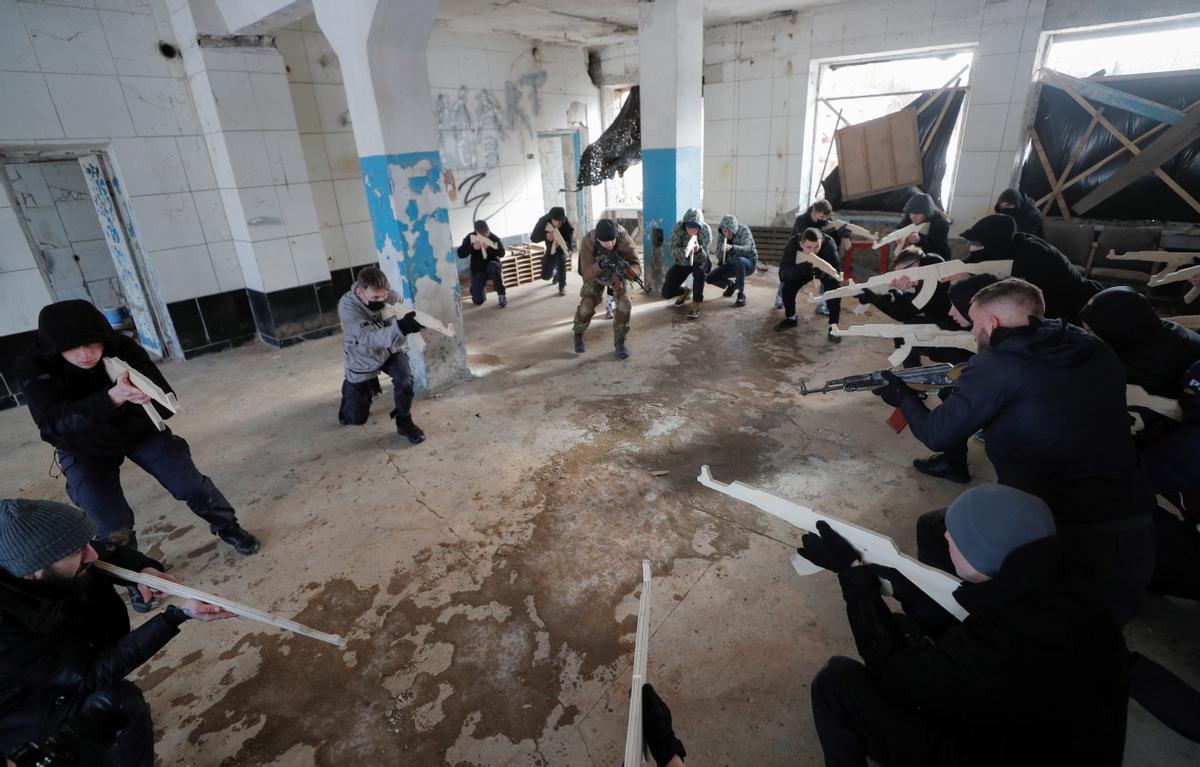 Un grupo de civiles ucranianos con armas de madera se entrenan en el interior de un edificio en Kiev.