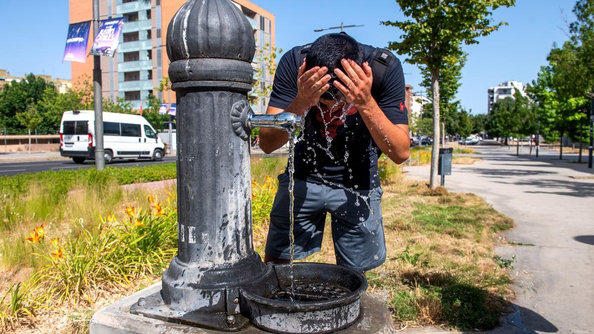 Jacob, estudiante de Lleida, se remoja en una fuente del fuerte calor