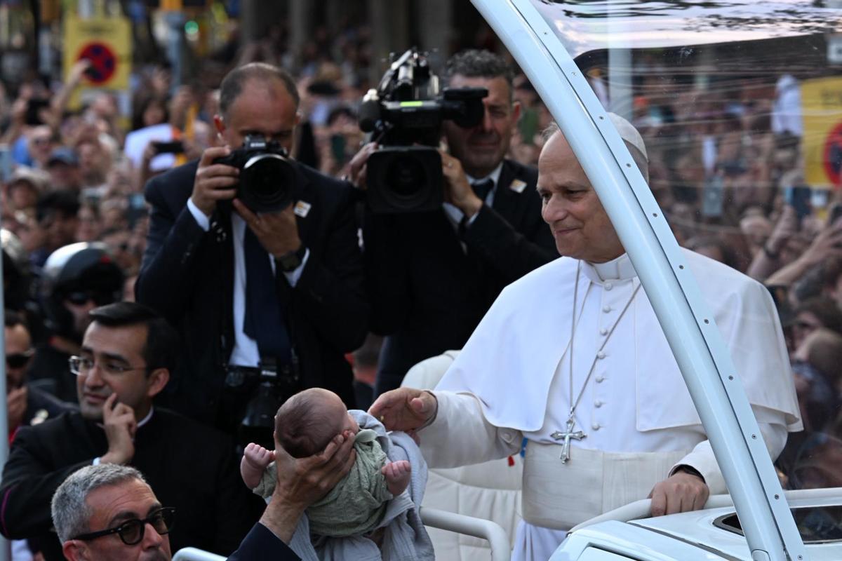 El papa bendicie a un bebé en su paso hacia la Sagrada Familia