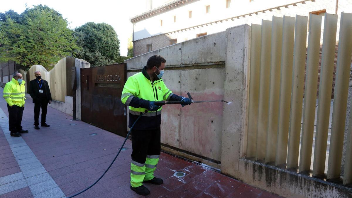 Operarios limpian las pintadas en la fachada de La Casa Museo Colón de Valladolid contra el Día de la Hispanidad