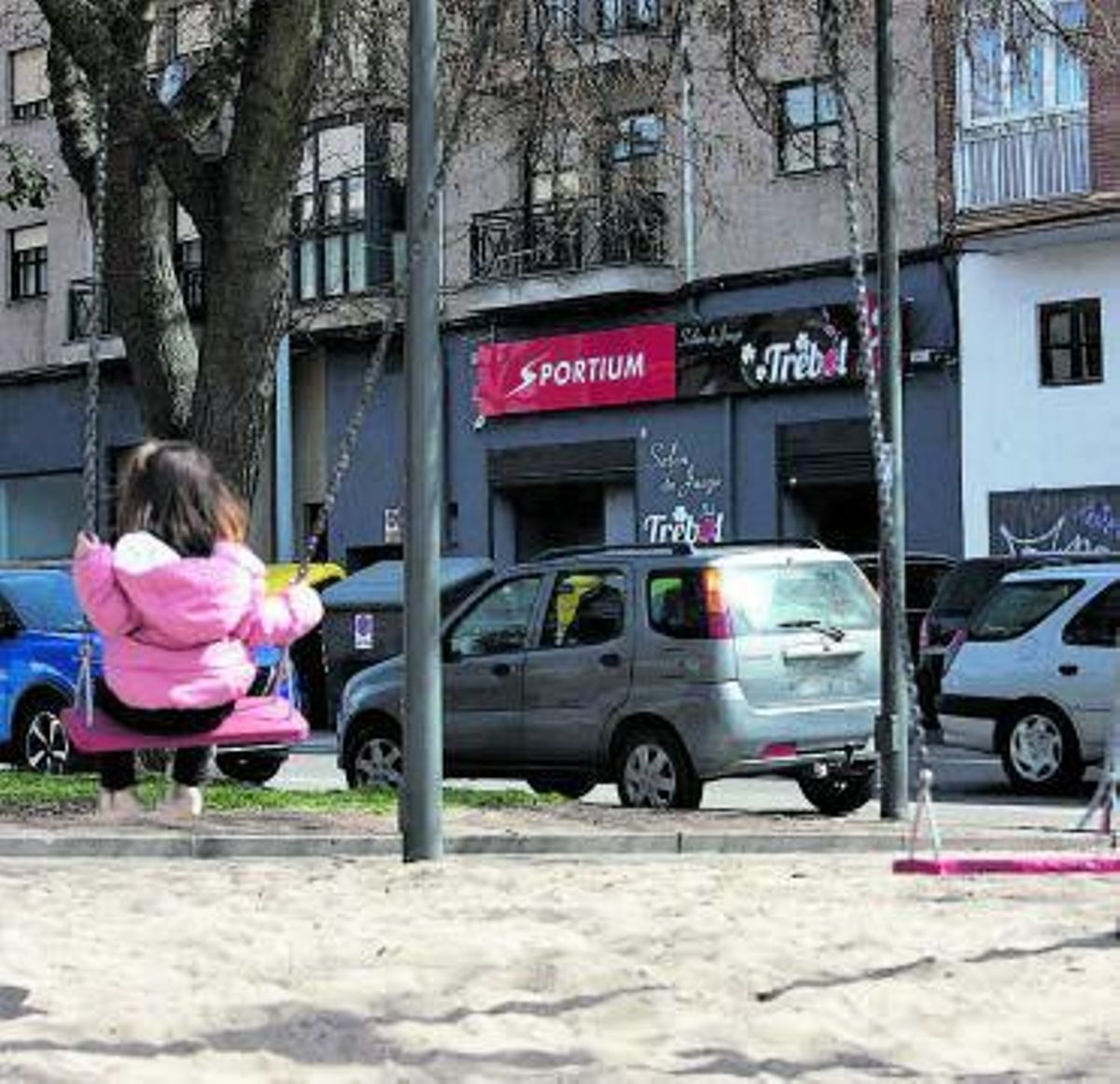 Una niña se columpia frente al Sportium de Obispo Nieto. | Ana Burrieza