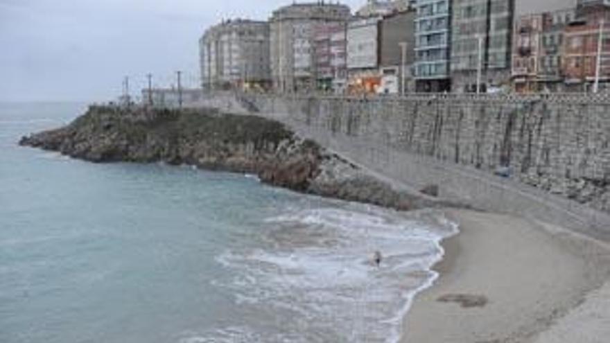 Un bañista en A Coruña un día de nubes y claros.