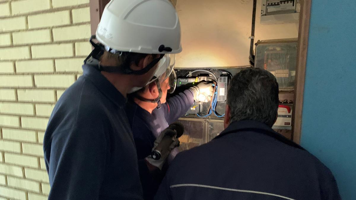Unos electricistas revisan un cuadro eléctrico.