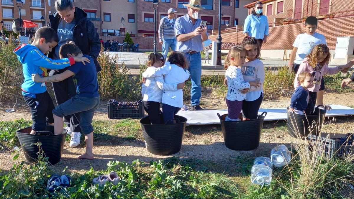 Varios niños del barrio disfrutan del pisado de uvas al estilo tradicional