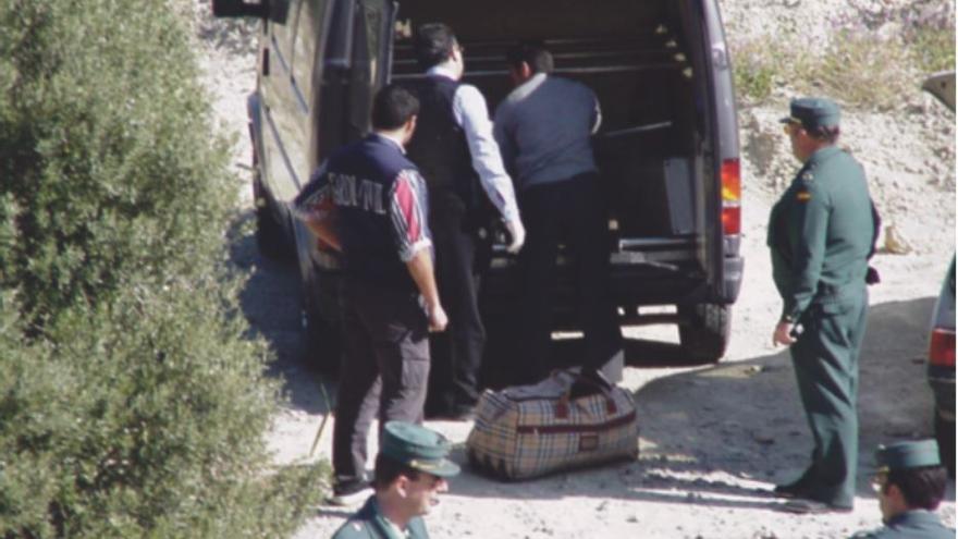 Agentes de la Guardia Civil trasladan las maletas con los restos humanos hallados en la N-332.