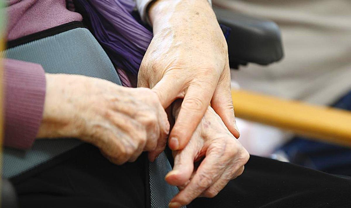 Una persona mayor es acompañada por un familiar en una residencia.