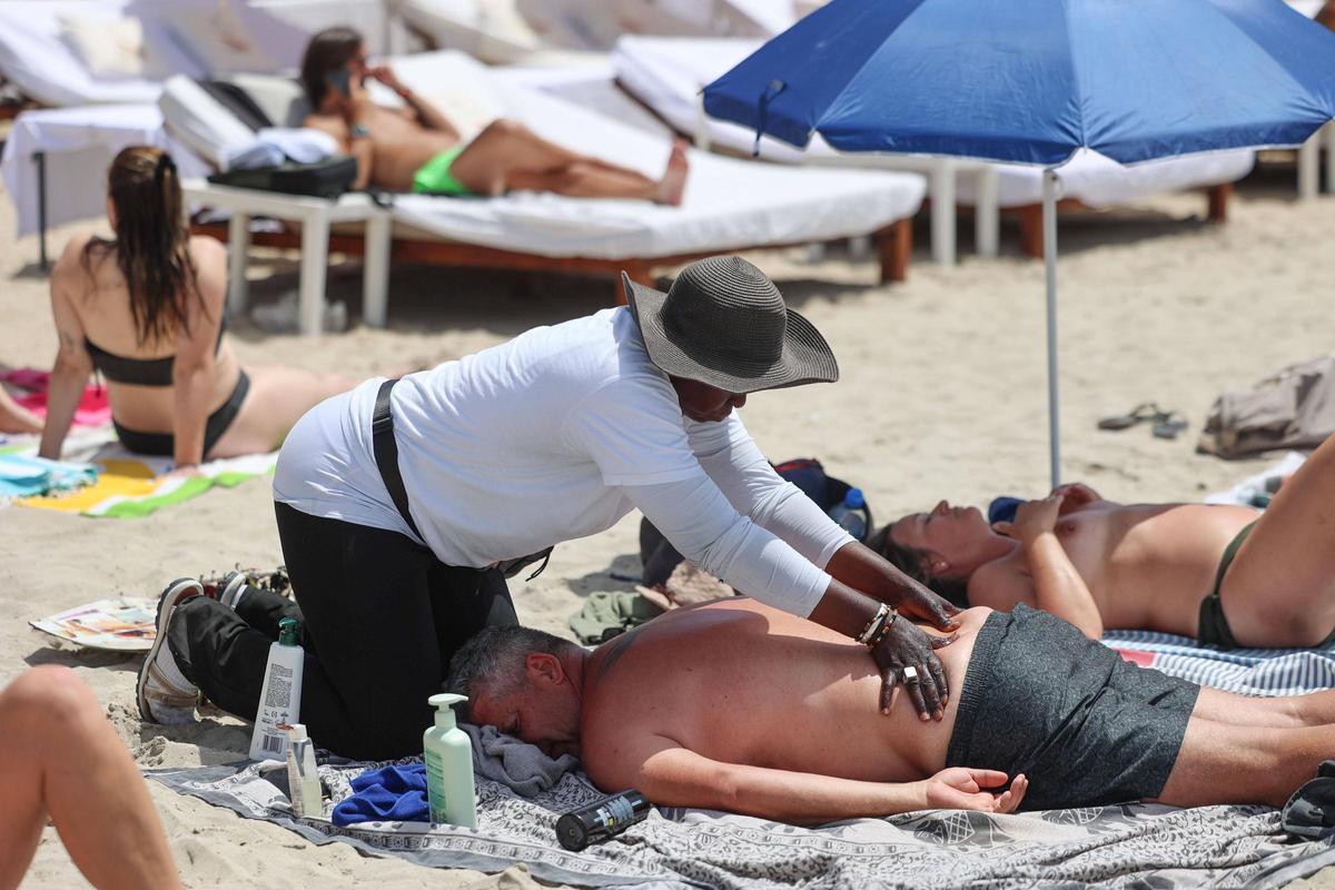 Un turista recibe un masaje sobre la arena