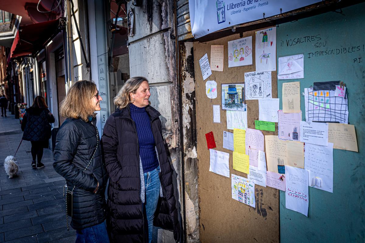 Las libreras de la plaza de Sarrià contemplan los mensajes y dibujos de apoyo depositados en la madera que cubre la entrada de su negocio