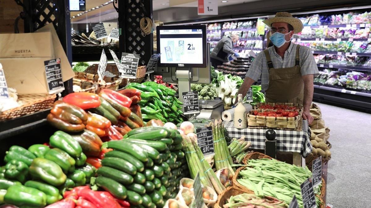 Un empleado de un supermercado de Madrid, con mascarilla y guantes.