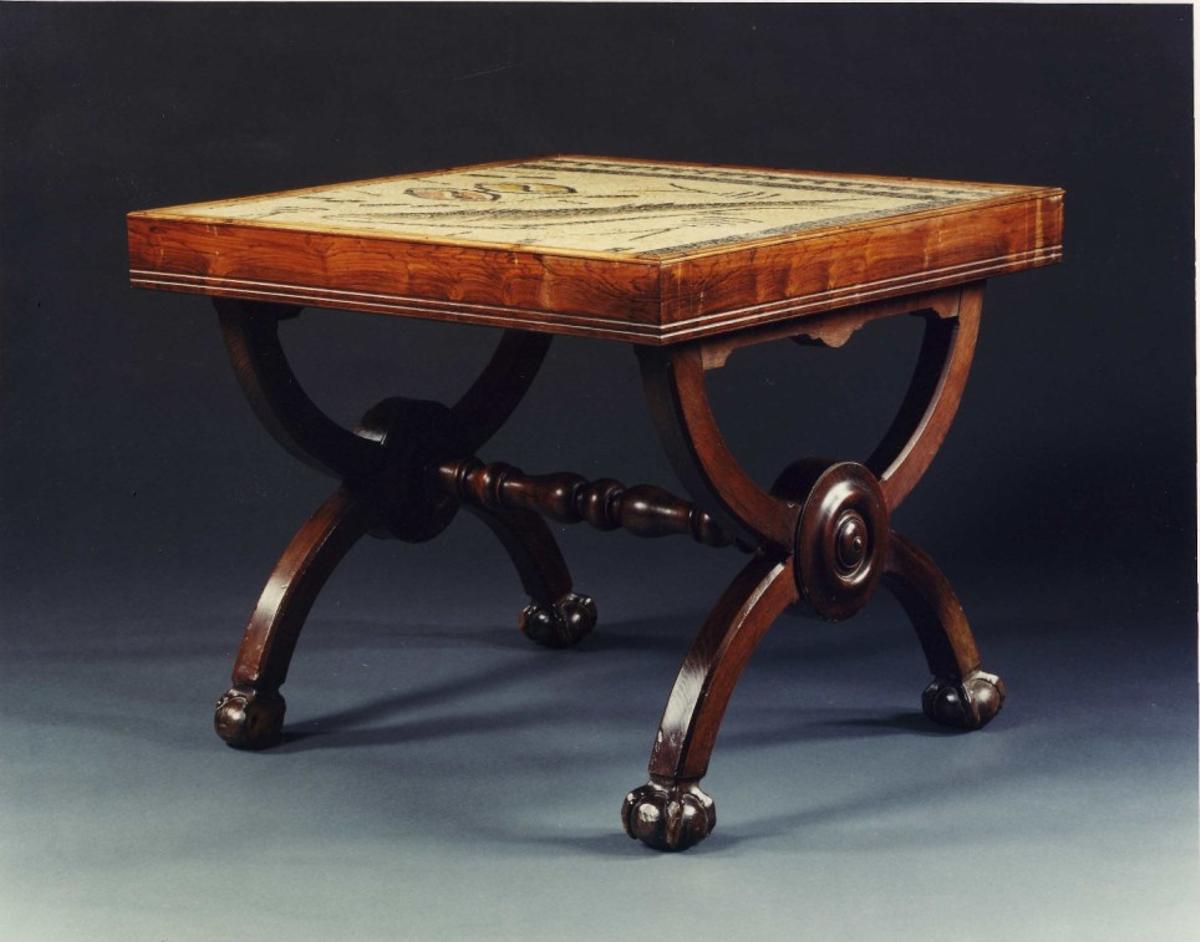 El mosaico está encastrado en una mesa auxiliar de madera.