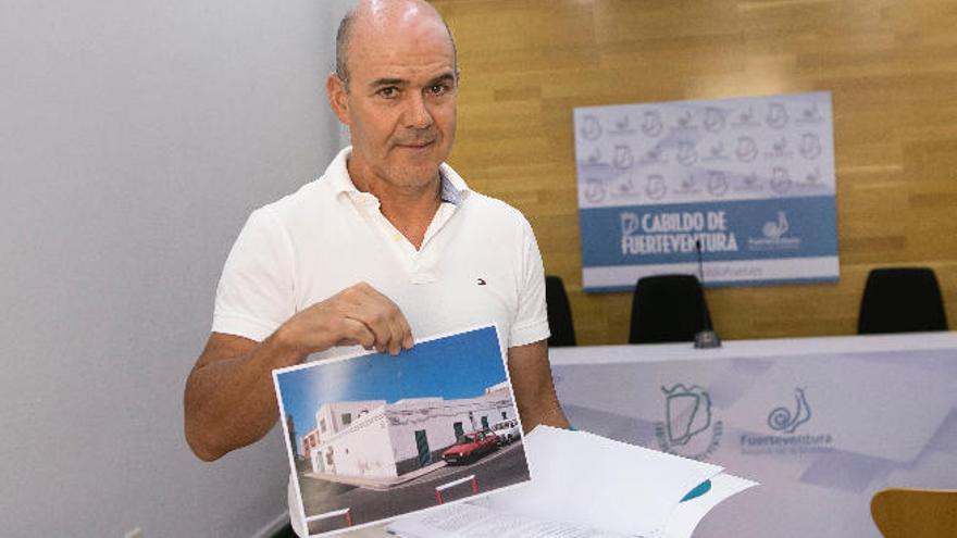 Miguel Socorro enseña la sentencia y la foto de la vivienda ganada.