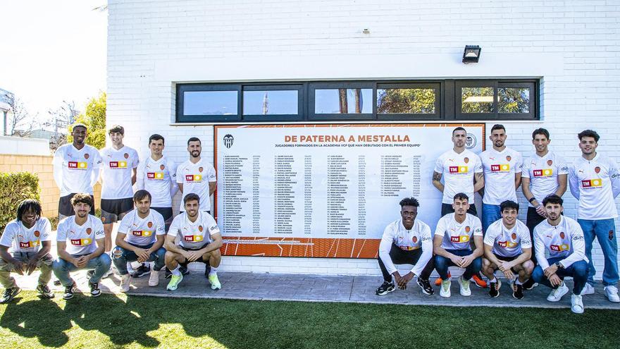 La foto de los jóvenes con el muro 'De Paterna a Mestalla' y los responsables del club y la Academia VCF