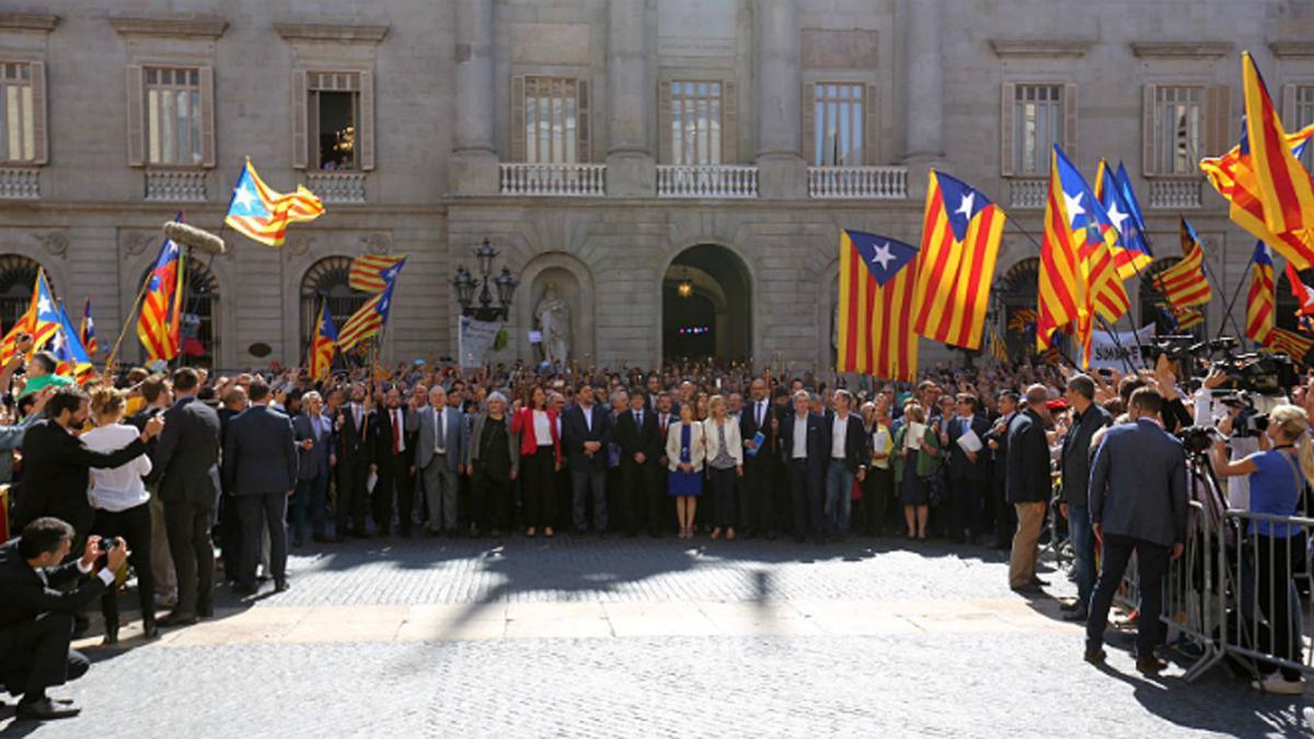 Los alcaldes y resto de autoridades cruzan la plaza Sant Jaume desde el ayuntamiento al Palau de la Generalitat.