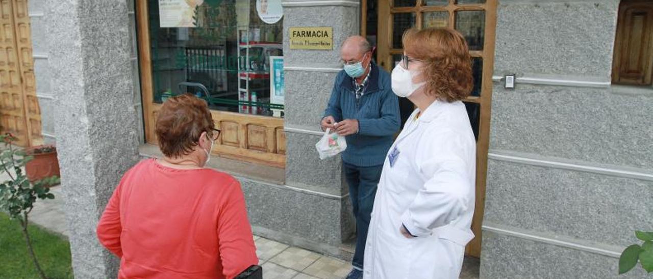 Purificación Sanmiguel en la farmacia que regenta con dos vecinos del municipio. |   // IÑAKI OSORIO