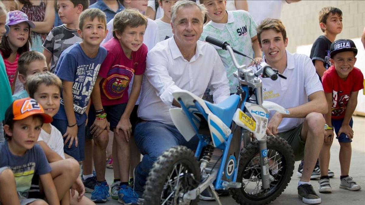 Alex Márquez, rodeado de niños y junto al director general de Rodi, Josep Esteve