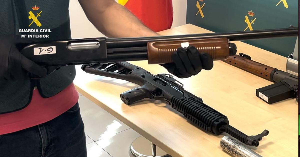 Un miembro de la Benemérita sostiene un arma larga decomisada a la red radicada en Alguazas.  | GC