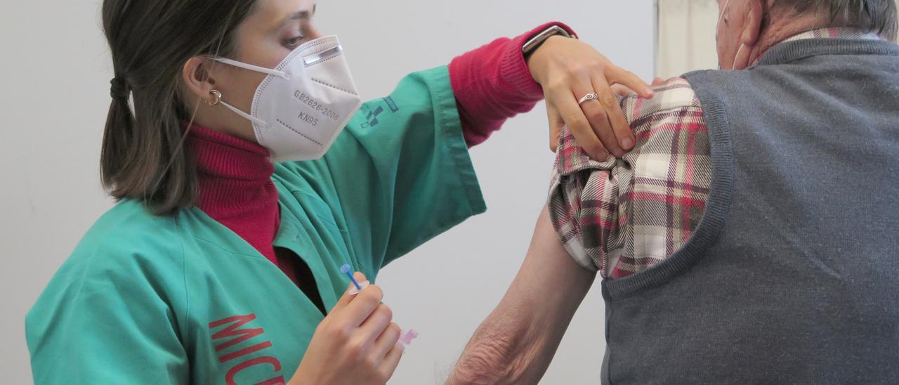 Un hombre recibe una dosis de vacuna en Gijón.
