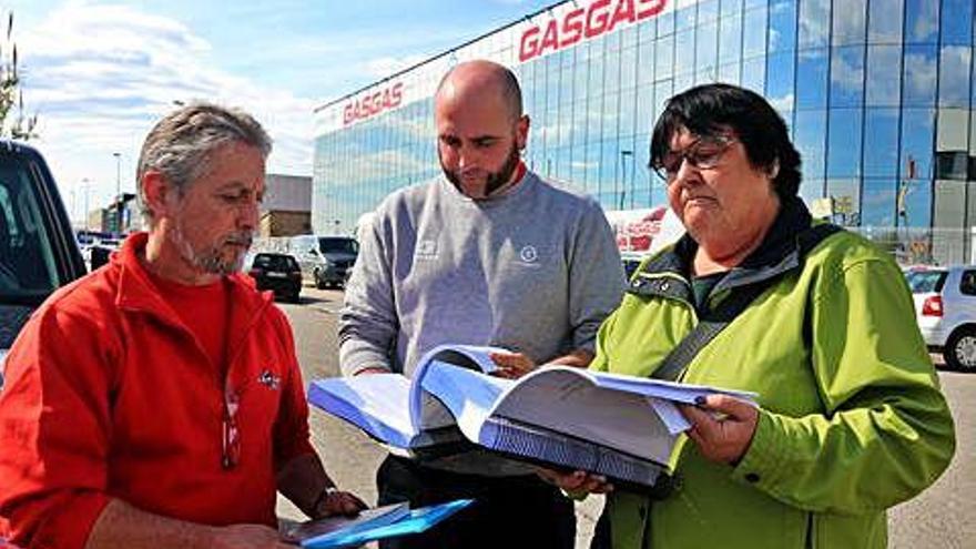 Els presidents del comitè i la secretària general de la FICA-UGT a Girona miren la documentació de l&#039;ERO.