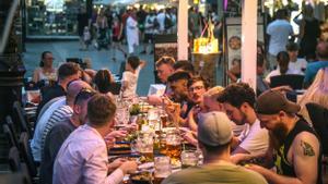 Un grupo cena en una terraza de la Rambla, donde consumen grandes jarras de cerveza.