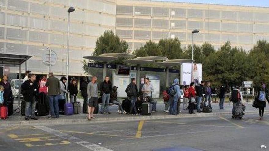 Un grupo de personas espera el autobús en la parada del aeropuerto de Son Sant Joan, en Palma.