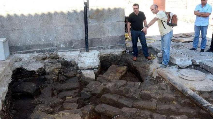 Los arqueólogos muestran al edil del centro histórico el hallazgo en las obras de la calle Barón.  // R. V.