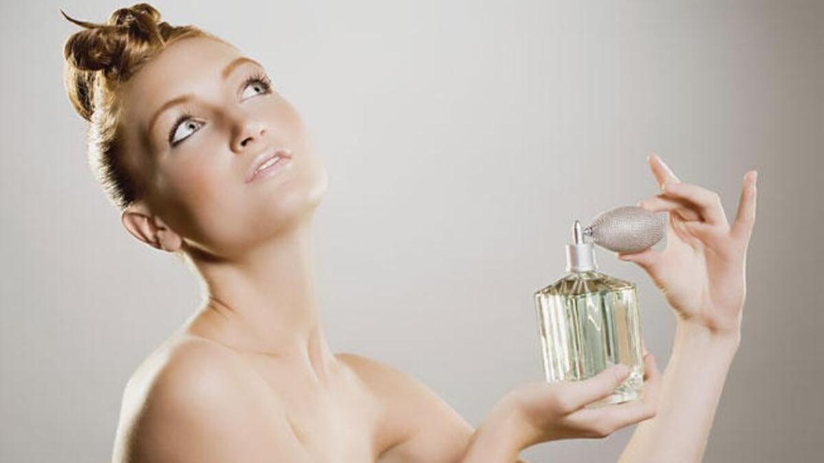 Una mujer se perfuma.