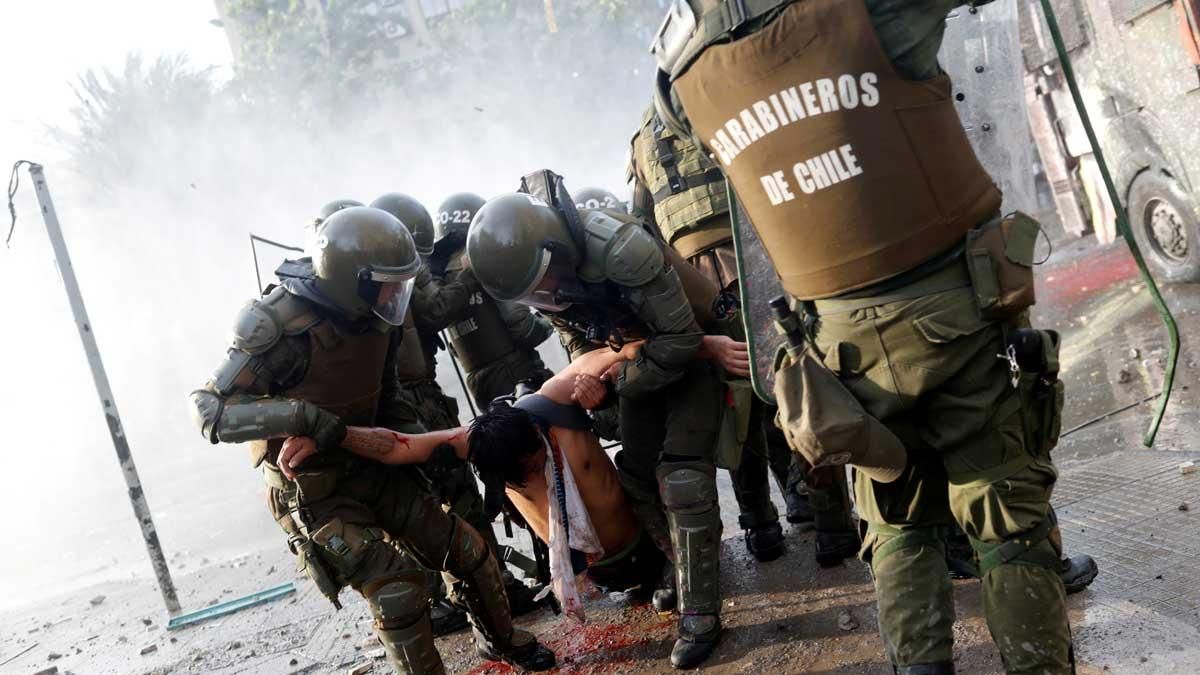 Chile, en ruta hacia una nueva Constitución, por la paz y por otro modelo de país. En la foto, un herido es trasladado por las fuerzas de seguridad durante las protestas en Santiago. 