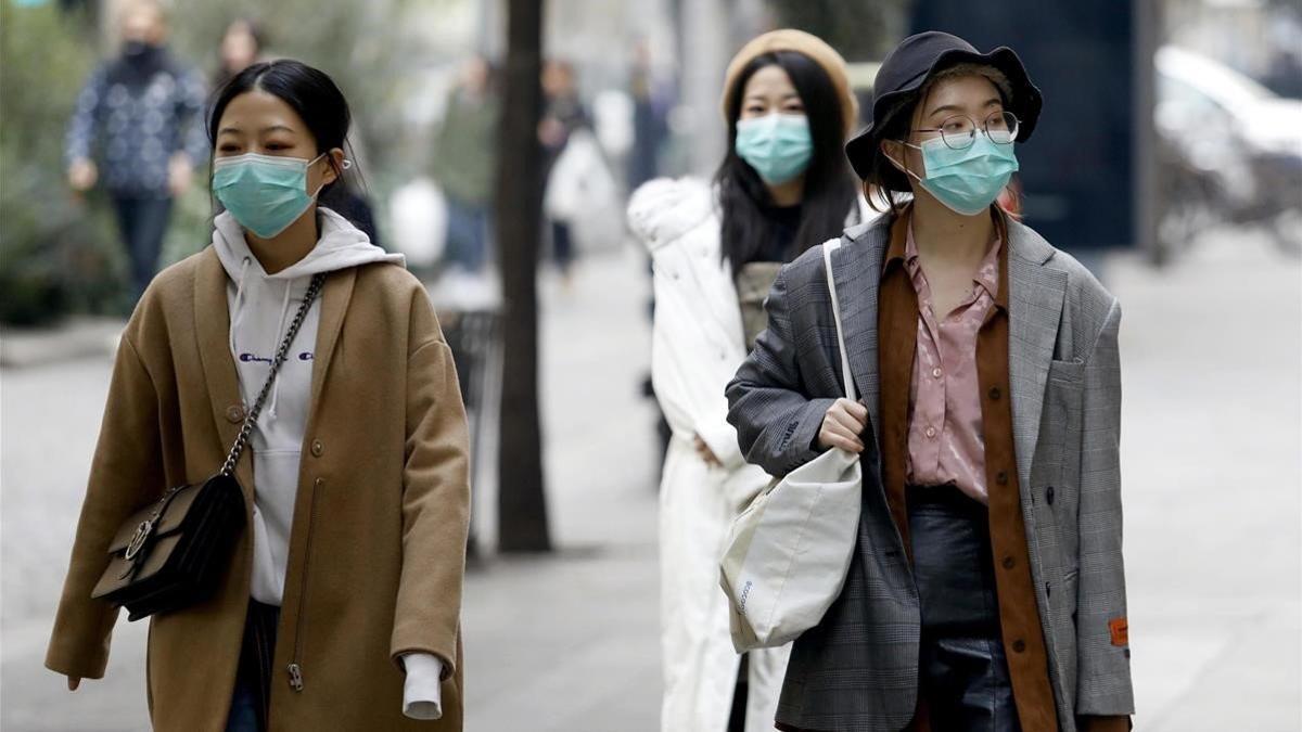 Unas mujeres asiáticas pasean por el centro de Milán con unas mascarillas médicas