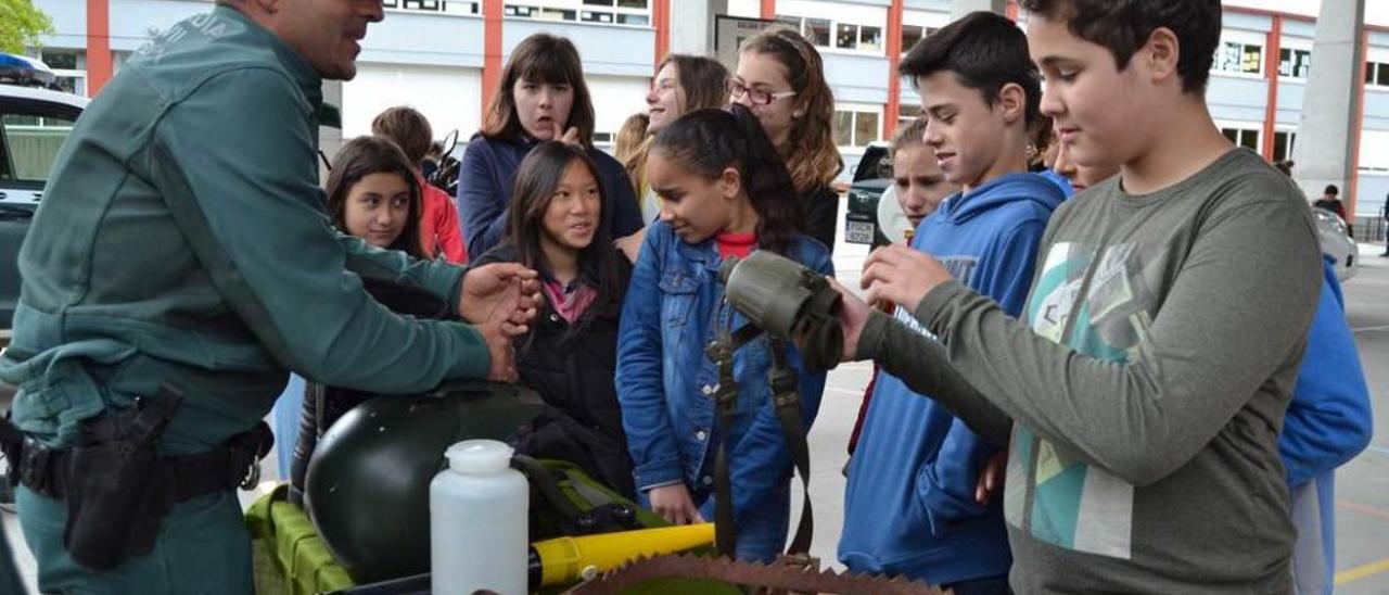 Un agente del Seprona de Panes muestra los prismáticos a varios alumnos de sexto de Primaria.