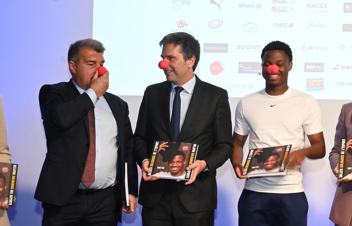 Laporta, Jordi Romañach, de El Corte Inglés, y Ansu Fati, en la presentación del 17 libro solidario. Laporta, Jordi Romañach, de El Corte Inglés, y Ansu Fati, en la presentación del 17 libro solidario.