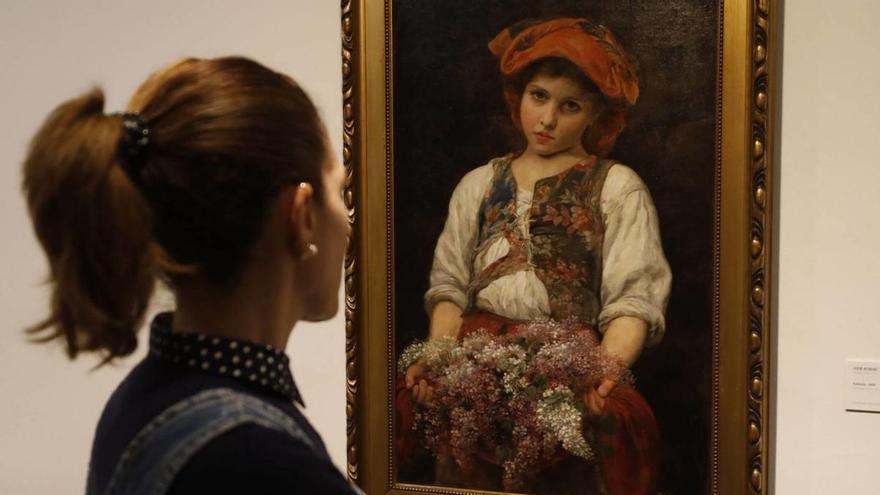 Una mujer contempla el cuadro «Florinda», de José Robles, propiedad del Prado y uno de los últimos depósitos que llegaron al Bellas Artes de Asturias este año, desde el Consulado de Tánger, donde estaba. | Luisma Murias