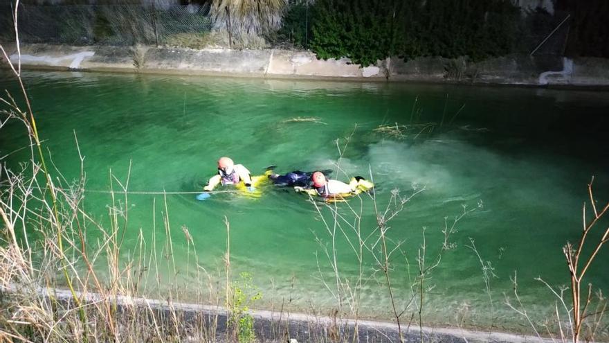 Los bomberos rescatan el cadáver del hombre ahogado en un canal de Torrent.