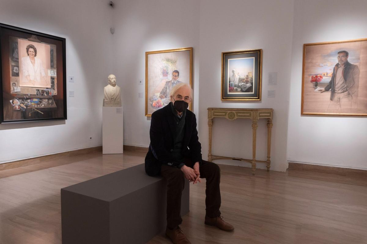 El artista Luis Massoni posa en el González Martí, detrás el cuadro de Rita Barberá.