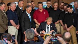 Trump, rodeado de mineros, firma la orden ejecutiva que pone los cimientos para deshacer la política medioambiental de Obama.