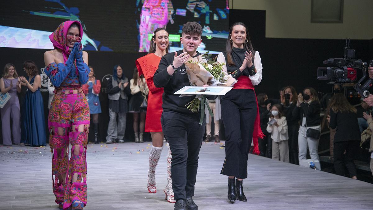 Alberto del Río, el sábado, recogiendo su premio acompañado de varias modelos que portan sus diseños.