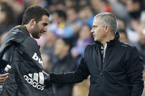 Real Madrid's coach Mourinho talks to Higuain as he leaves the pitch during their Spanish First Division soccer match against Sporting Gijon in Madrid